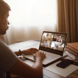 Man Working From Home Having Online Group Videoconference On Laptop